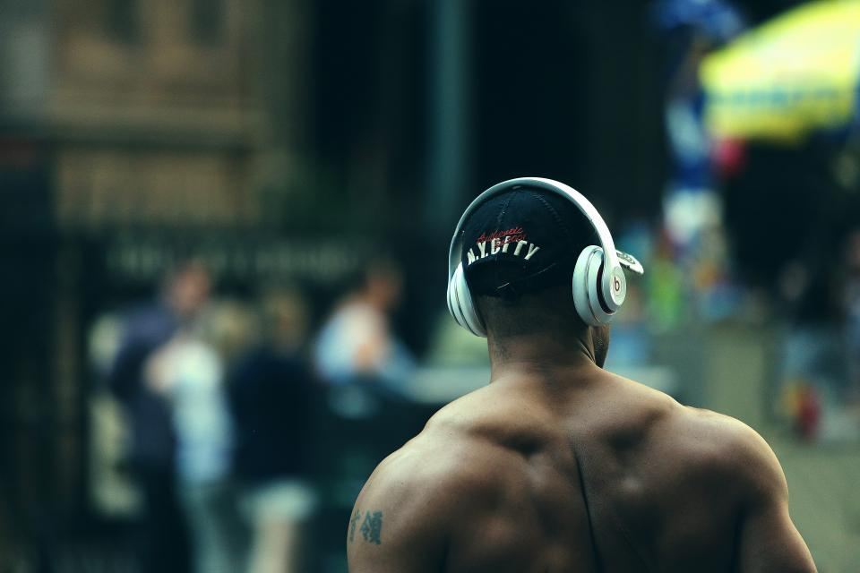 Man wearing headphones walking through a city at night