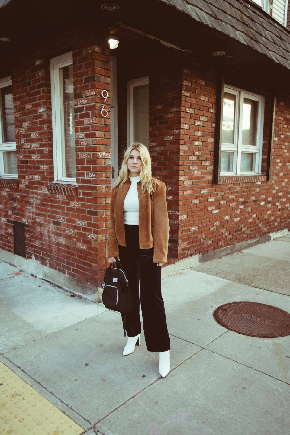 Model in a camel wool coat and wide trousers on a city street