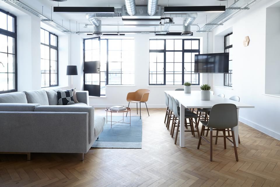 An open living and dining room with tall black-framed windows