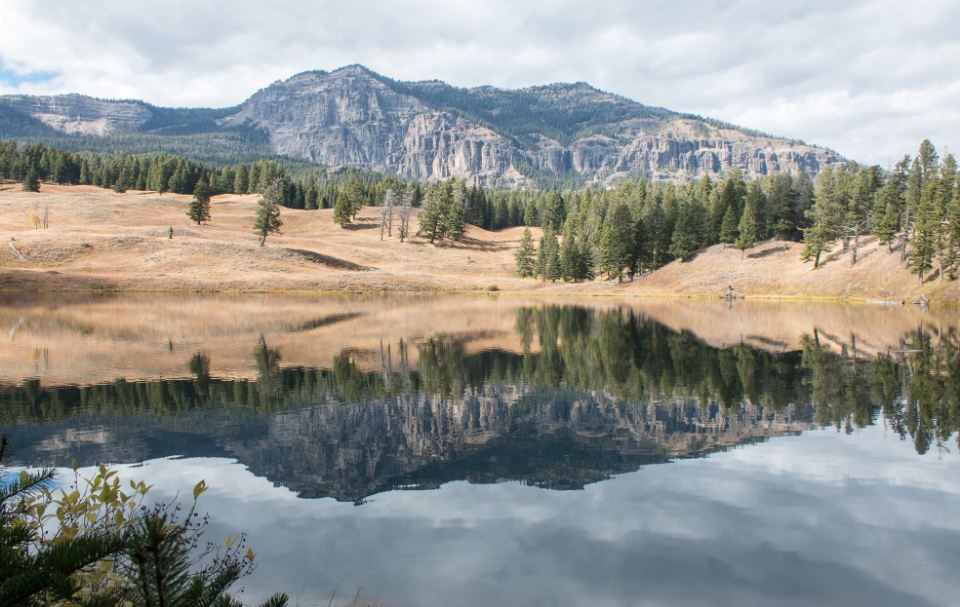 Dry brown mountains reflected in a still high-altitude lake